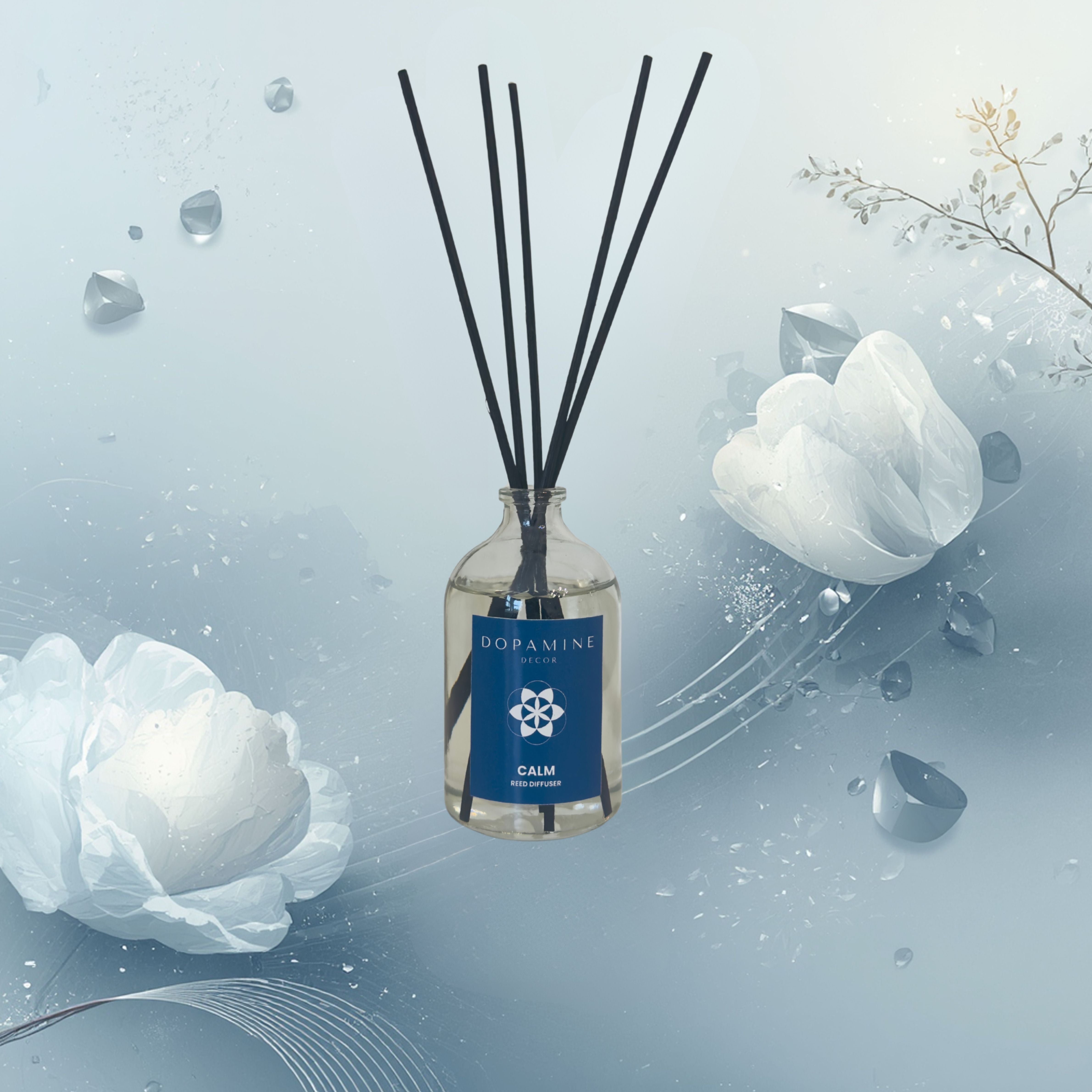 Dopamine Decor blue calm lavender diffuser bottle with black sticks on a light blue background with white flowers and ice crystals.